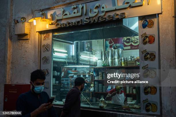 July 2022, Qatar, Doha: An employee of a candy store pours liquid Qatari halwa into a bowl. The Islamic Festival of Sacrifice begins in the Gulf...