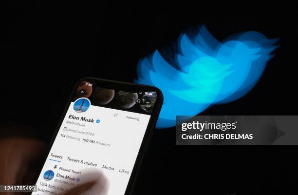 This illustration photo taken on July 8, 2022 shows Elon Musk's Twitter page displayed on the screen of a smartphone with Twitter logo in the...