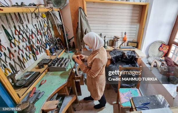 Libyan woman crafts traditional filigree jewellery at a workshop in the capital Tripoli on March 29, 2022. - In Tripoli's Old City, young Libyans...