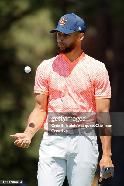 Basketball player Stephen Curry tosses a ball while walking on the 17th green during Round One of the 2022 American Century Championship at Edgewood...