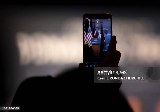An attendee takes video as former US President Donald Trump speaks at a rally endorsing Republican candidates Adam Laxalt and Joe Lombardo July 8 in...