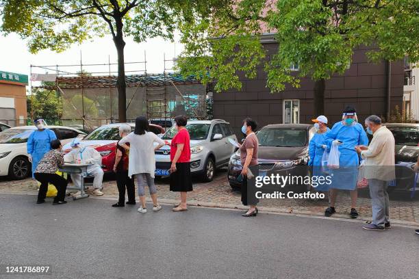 Residents line up to take nucleic acid samples at a residential area in Pudong New Area, Shanghai, China, July 9, 2022.