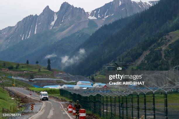 Helicopter carries flash flood affected victims of the Amarnath pilgrimage as an ambulance drives past near Baltal base camp in Kashmir on July 9,...