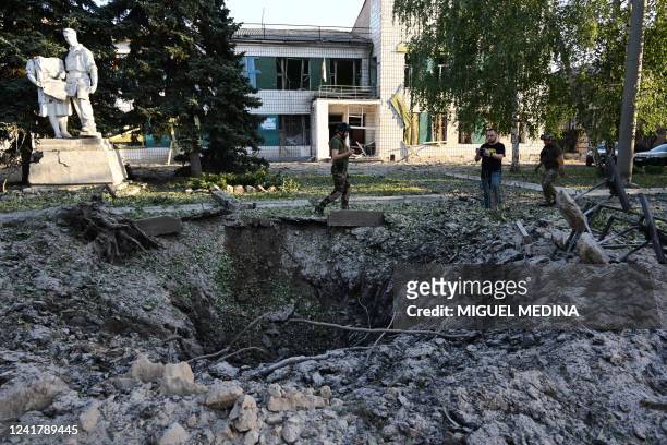 Residents observe the hole and the damage caused in the House of the Culture, in Druzhkivka, south of Kramatorsk, eastern Ukraine, following a...
