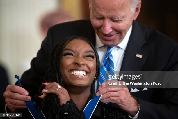 President Joe Biden presents the Presidential Medal of Freedom to Olympic gymnast Simone Biles, during a medal ceremony inside the East Room at the...