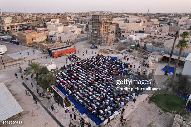 July 2022, Iraq, Mosul: Muslims perform prayers of Eid al-Adha, the holiest feast in Islam, at the courtyard of the Great Mosque of al-Nuri, which...