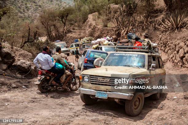 This picture taken in the mountains near Yemen's third-largest city of Taez, shows traffic on a heavily damaged narrow road that serves as a lifeline...