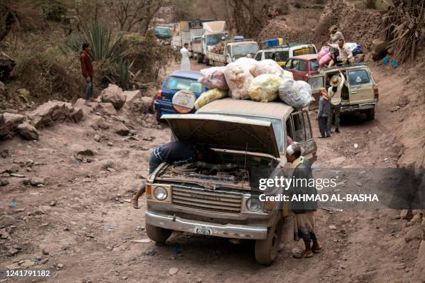 This picture taken in the mountains near Yemen's third-largest city of Taez, shows traffic on a heavily damaged narrow road that serves as a lifeline...