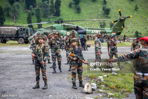 Indian army soldiers stand guard near their chopper carrying injured Indian pilgrims after flash floods on July 9, 2022 in Baltal 100 km east of...