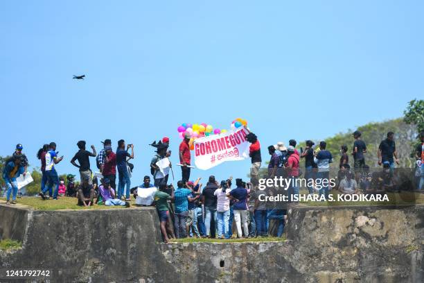 Protestors participate in an anti-government demonstration outside the Galle International Cricket Stadium during the second day play of the second...