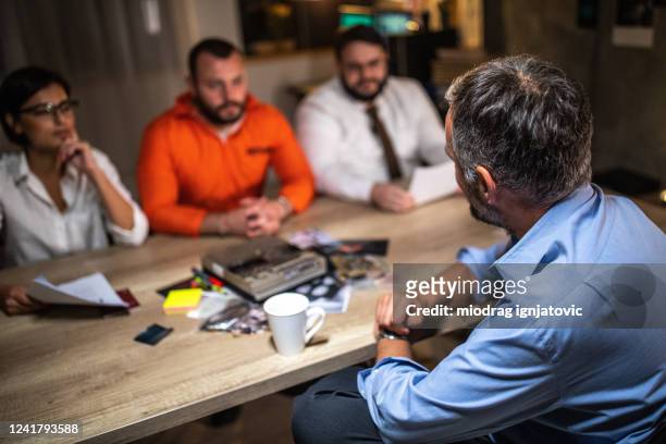 prisoner being interviewed by detectives in presence of his lawyer at interrogation room - criminal lawyer stock pictures, royalty-free photos & images