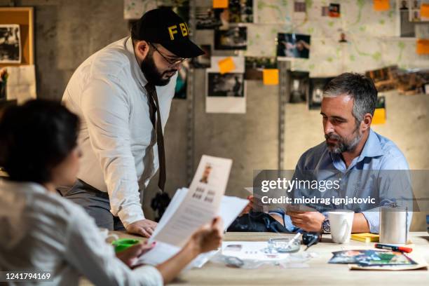 hardworking fbi agents working late hours at night in the office - fbi director stock pictures, royalty-free photos & images