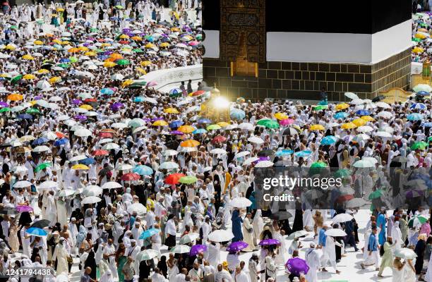 Worshippers stand near the Maqam Ibrahim as they circumambulate the Kaaba, Islam's holiest shrine, at the Grand mosque in the holy Saudi city of...