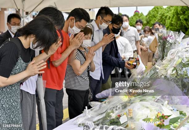 People pray on July 9 near the location of the fatal shooting the previous day of former Japanese Prime Minister Shinzo Abe during election...