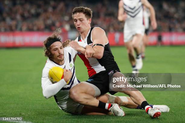 James Aish of the Dockers is tackled by Jack Billings of the Saints during the 2022 AFL Round 17 match between the St Kilda Saints and the Fremantle...