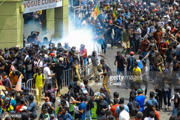 Police fire tear gas canisters to disperse protesters demanding the resignation of Sri Lanka's President Gotabaya in a street leading to Sri Lanka's...