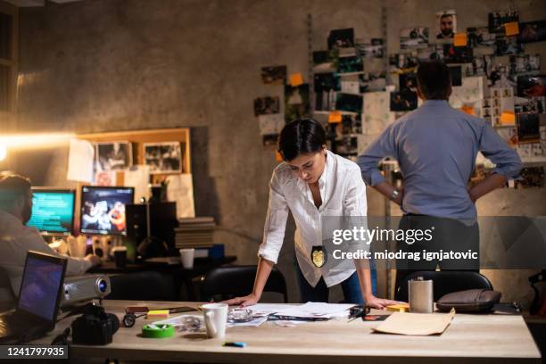 female detective working late at night at office - fbi director stock pictures, royalty-free photos & images