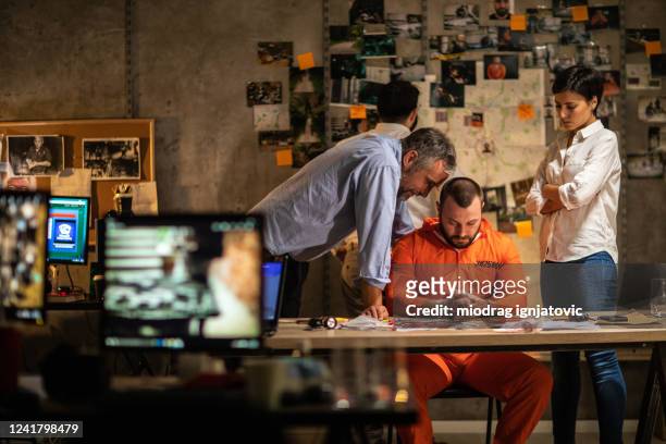 fbi detectives interrogating prisoner about murder case late at night at office - fbi director stock pictures, royalty-free photos & images