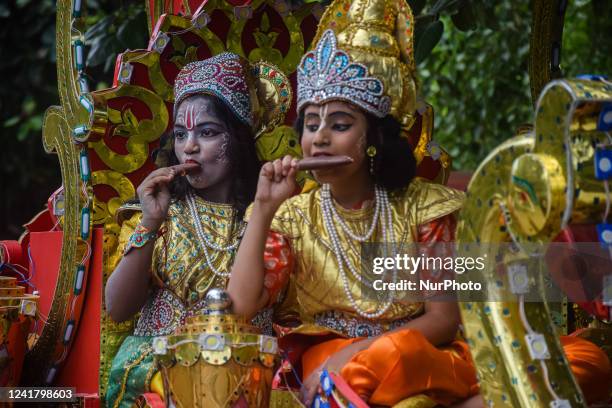 Children, dressed as Hindu god Krishna and Arjuna, one of the protagonists in the ancient Indian epic called Mahabharata , eat ice cream during the...