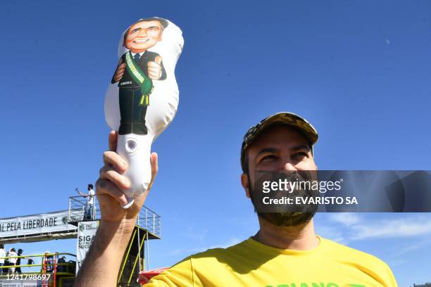 Man holds up an inflatable doll depicting Brazilian President Jair Bolsonaro during a pro-arms demo called by his son, lawmaker Eduardo Bolsonaro, in...