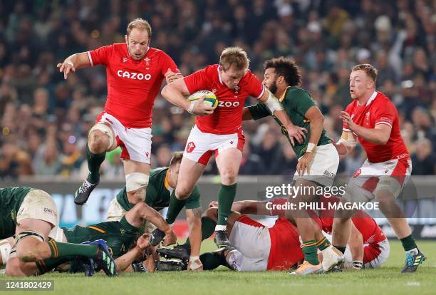 Wales' centre Nick Tompkins runs with the ball as he evades a tackle during an international rugby union match between South Africa and Wales at the...