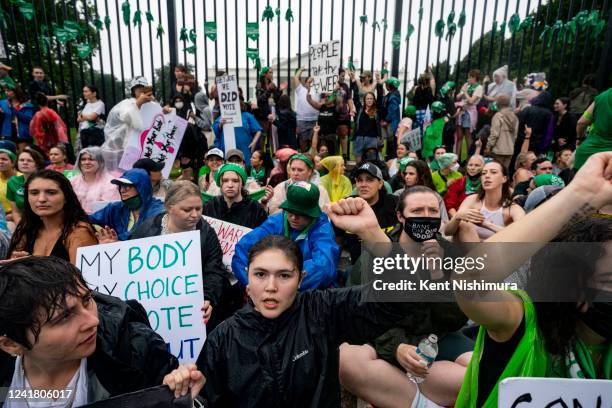 Abortion rights activists stage a sit-in just outside of the White House security fence to denounce the U.S. Supreme Court decision to end federal...