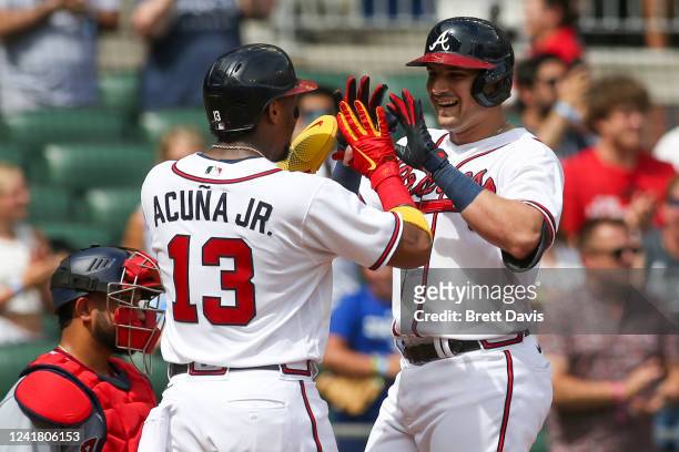 Austin Riley celebrates with Ronald Acuna Jr. #13 of the Atlanta Braves after a two-run home run against the Washington Nationals in the first inning...