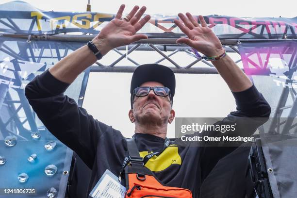 Matthias Roeingh, better known as Dr. Motte and co-founder of the Loveparade, gestures to revelers from a music truck during the 2022 Loveparade...