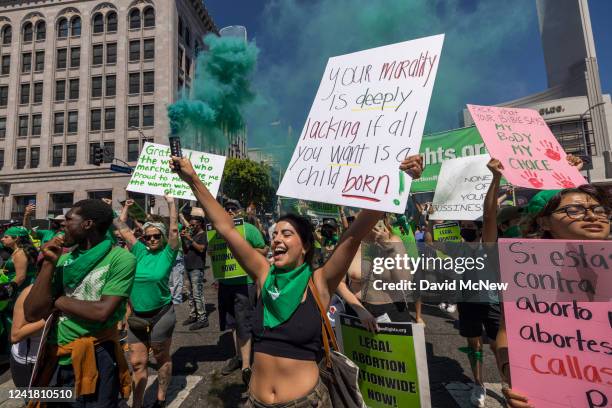 Woman holds a green smoke grenade as protesters march on Hollywood Boulevard to denounce the U.S. Supreme Court on July 9, 2022 in the Hollywood...