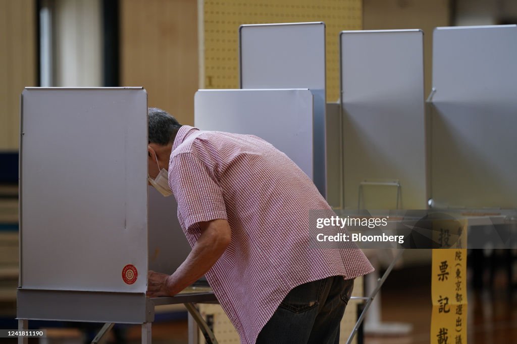 A voter casts a ballot at a polling location in the Minato District