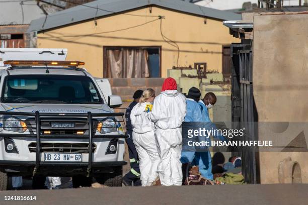 Members of the South African Police Service and forensic pathology service inspect the scene of a mass shooting in Soweto, South Africa, on July 10,...