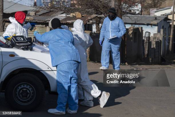 Security forces and forensic service inspect the scene of a mass shooting in Soweto, South Africa, on July 10, 2022. Fourteen people have been killed...