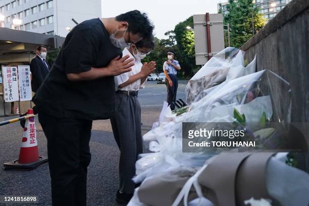 Mourners offer flowers near at the entrance of the Liberal Democratic Party headquarters building in Tokyo on July 10 following the assassination of...