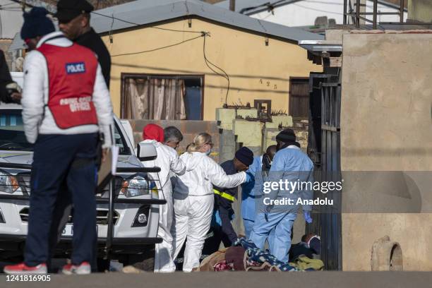 Security forces and forensic service inspect the scene of a mass shooting in Soweto, South Africa, on July 10, 2022. Fourteen people have been killed...