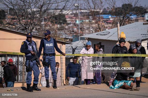 Relative of one of the 14 victims shot dead in a tavern in Soweto reacts next to the crime scene in Soweto on July 10, 2022. Fourteen people were...