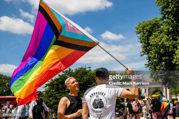 Protesters with a Progress Pride flag assemble to take part in a London Trans+ Pride march from the Wellington Arch to Soho on 9th July 2022 in...