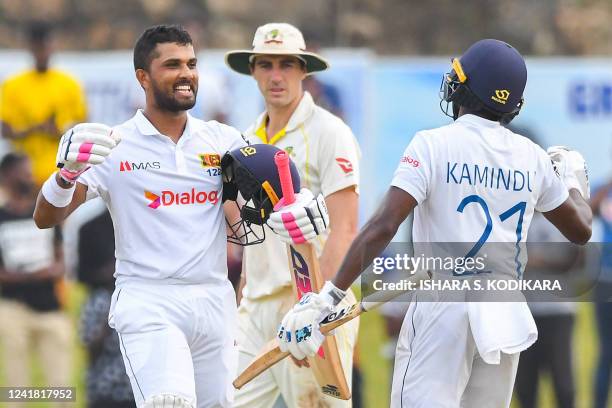 Sri Lanka's Dinesh Chandimal celebrates with Kamindu Mendis after scoring a century as Australia's Captain Pat Cummins watches during the third day...