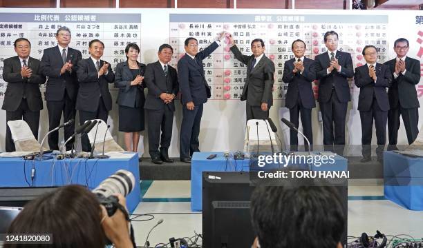 Japan's Prime Minister and the President of the Liberal Democratic Party Fumio Kishida places a red paper rose on a LDP candidate's name to indicate...