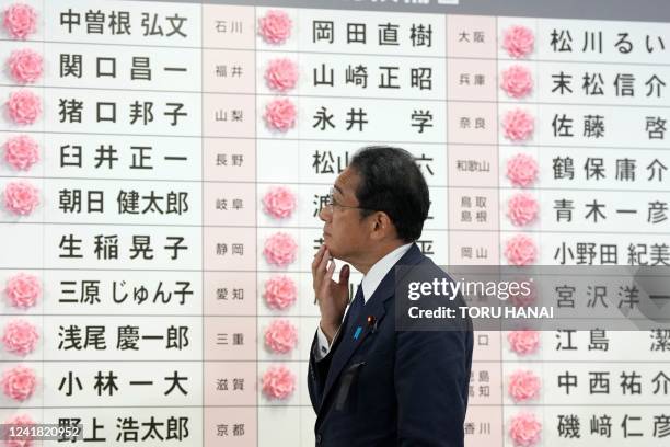 Japan's Prime Minister and the President of the Liberal Democratic Party Fumio Kishida watches after placing a red paper rose on a LDP candidate's...