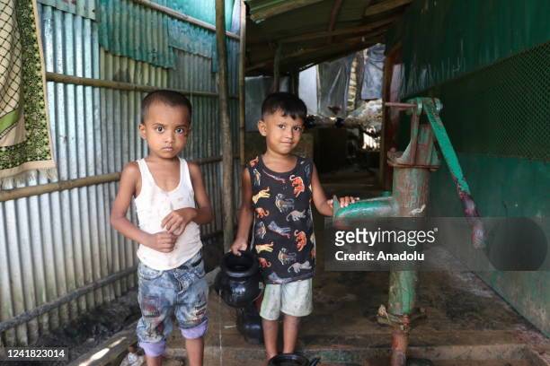 Children fill a black jug with water in Cox's Bazar, Bangladesh on July 09, 2022. More than a million Rohingya Muslims, who were displaced due to the...
