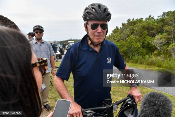 President Joe Biden stops to talk to reporters during a bike ride in Gordons Pond State Park in Rehoboth Beach, Delaware on July 10, 2022. / "The...