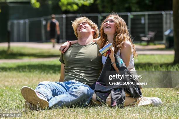 Couple enjoys the hot and sunny day in London. According to the Met Office mini heatwave will continue in London and a high of 32 degrees Celsius is...