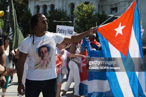 Singer Yotuel Romero holds a Cuban flag during the demonstration to demand the end of the dictatorship and the freedom of political prisoners in Cuba...