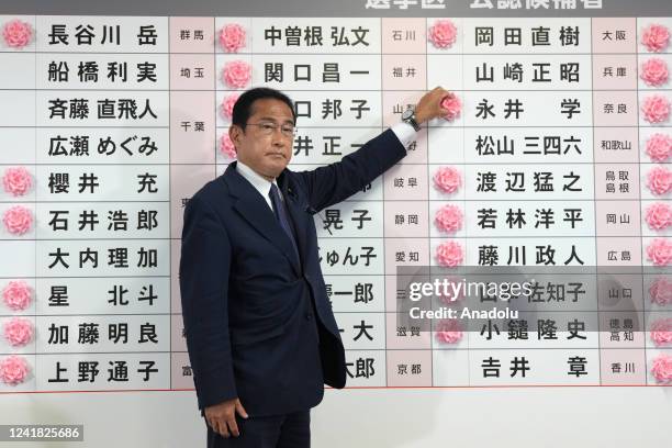 Fumio Kishida, Japan's prime minister and president of the Liberal Democratic Party , places a rose on an LDP candidate's name, to indicate a victory...