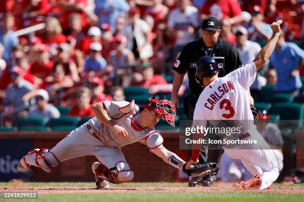 St. Louis Cardinals center fielder Dylan Carlson slides at home plate ahead of the tag by Philadelphia Phillies catcher J.T. Realmuto to score the go...