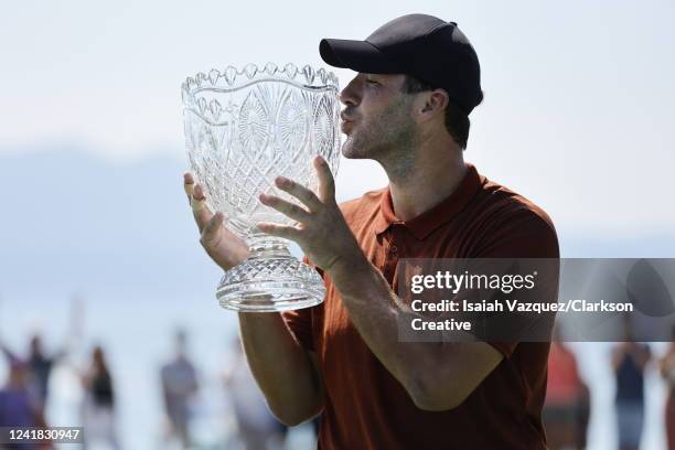 Former NFL quarterback Tony Romo kisses the trophy after winning the American Century Championship at Edgewood Tahoe Golf Course on July 10, 2022 in...