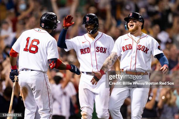 Xander Bogaerts and Alex Verdugo of the Boston Red Sox high five Franchy Cordero after scoring during the seventh inning of a game against the New...