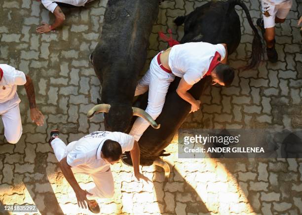 Participants run ahead of Jose Cebada Gago bulls during the fifth "encierro" of the San Fermin festival in Pamplona, northern Spain on July 11, 2022....