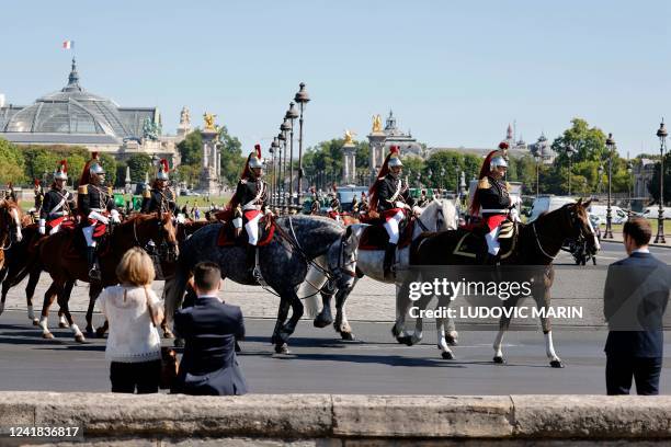 French Mounted Republican guards arrive for a "present arms" and decoration ceremony in the courtyard of The Invalides, in Paris, on July 11, 2022. -...