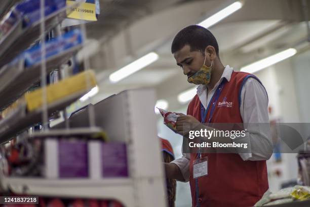Worker at the cash register at a supermarket in New Delhi, India, on Sunday July 10, 2022. India is scheduled to release consumer price index figures...